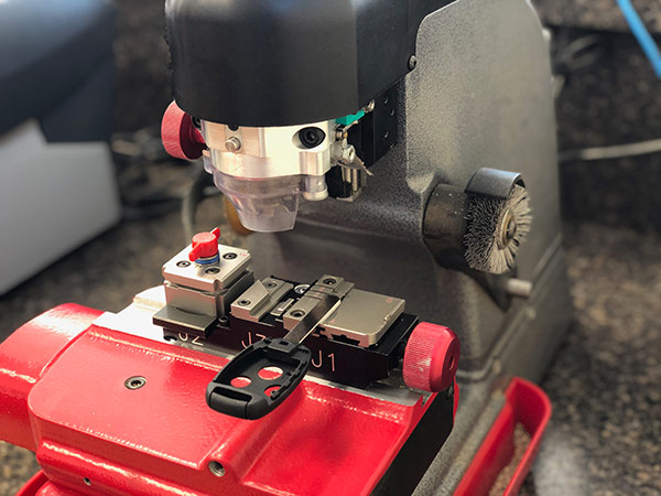 Car keys being cut on a key cutting machine.