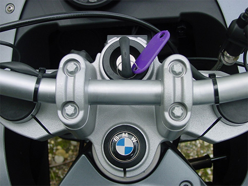 image of a BMW motorcycle with a newly-cut key in the ignition.